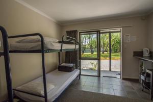 蒂阿瑙峡湾美景假日公园的客房设有两张双层床和一扇通往庭院的门