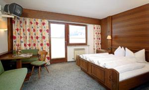 索尔登奥彭纳伊姆马蒂亚斯酒店的酒店客房配有一张床、一张书桌和一张四柱床