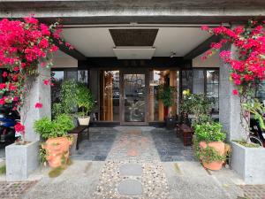 台南奇遇果文旅 Key We Go Hotel 的花卉和植物的建筑的前门