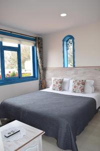 昆卡La Casa Azul的一间卧室设有一张大床和两个窗户。