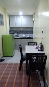 Kampong Telok Gadong KechilHOMESTAY KAMPUNG DELEK BARU, KLANG的厨房配有桌椅和绿色冰箱。
