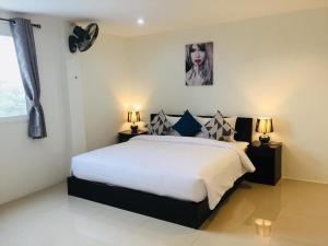 卡马拉海滩Baba Guest House的一间卧室配有一张带两盏灯的床,墙上挂着一张照片