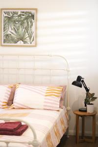 耐莉湾Island Cottages的卧室配有白色床、灯和植物