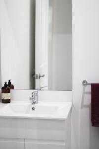 耐莉湾Island Cottages的浴室设有白色水槽和镜子