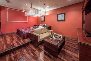 宇都宫Restay Utsunomiya (Adult Only)的红色的房间,配有床和沙发