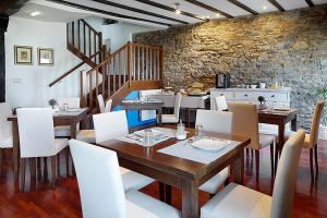 吉塔里亚卡塔伯纳旅馆的一间带木桌和白色椅子的用餐室