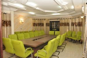 科托努Diamond hotel的一间会议室,配有长桌和绿色椅子