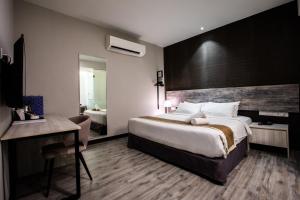 新山列韦瑞吉商务酒店（士姑来）的酒店客房设有一张大床和一张书桌。