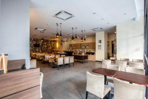 新山列韦瑞吉商务酒店（士姑来）的配有木桌和白色椅子的餐厅