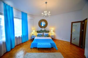 德瓦Casa Negustorului的一间卧室配有蓝色的床和吊灯。