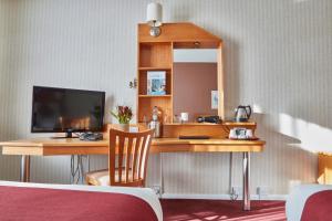 普里茅斯普利茅斯未来旅馆的酒店客房设有一张书桌和电视