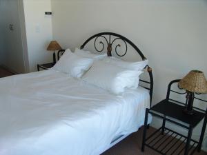 比格湾Bradclin Beach Blouberg的一张白色的大床,配有白色枕头