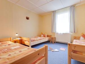 青斯特Tranquil Holiday Home in Zingst Germany with Terrace的带三张床和窗户的客房