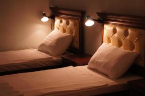 塔什干Art Hostel的一间卧室配有两张带白色床单和枕头的床。