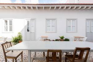里斯本Patio São Vicente的白色房子前面的白色桌子和椅子