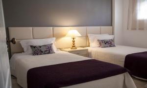 波尔蒂芒雅尔丁做勒沃公寓式酒店的一张桌子上灯的房间里两张床铺