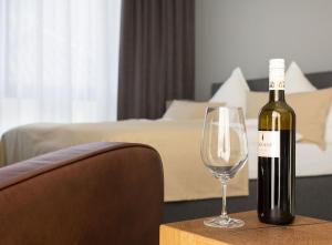 吕讷堡anders Kontorhaus Hotel的一张桌子上坐着一瓶葡萄酒和一杯葡萄酒