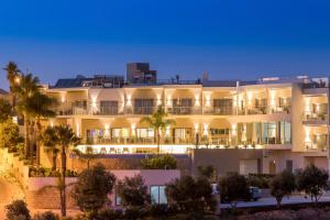 费拉古多Caneiros Luxury House & Suites的一座白色的大建筑,前面有棕榈树