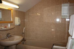 凯拉地区莫利讷Hotel Le Chamois Logis的浴室配有盥洗盆、浴缸和盥洗盆
