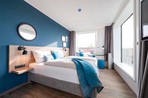 康斯坦茨HARBR. hotel Konstanz的一间卧室设有一张蓝色墙壁的大床