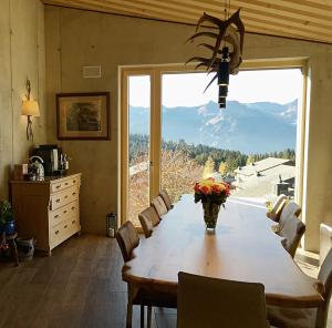 艾姆敦Mountain Chalet Amden的一间带桌子和大窗户的用餐室