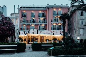 皮兰塔迪尼艺术酒店的前面有长凳的粉红色大建筑