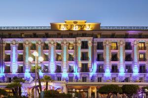 尼斯昂格鲁大道皇家酒店的一座晚上亮着蓝色灯的建筑