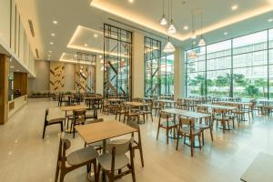 乔木提恩海滩Paragon Grand Resort的餐厅设有桌椅和窗户。