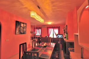 贝纳尔马德纳Chalet H GOLF的一间拥有红色墙壁和桌椅的用餐室