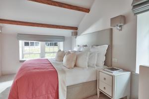 温德米尔The Samling Hotel的卧室配有带白色枕头的床和窗户。