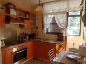圣克鲁斯-德拉帕尔马La Quinta Verde的厨房配有橙色橱柜、桌子和窗户。