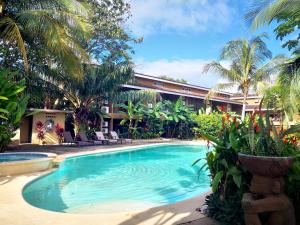 格兰德海滩Cabo Velas Estates的棕榈树建筑前的游泳池