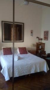 布宜诺斯艾利斯阿里巴大街住宿加早餐酒店的卧室配有带红色枕头的大型白色床