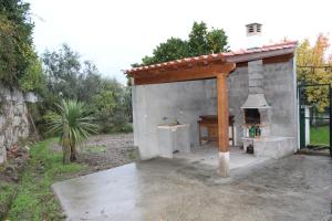 ArcozeloCasa do Adro的庭院内带木屋顶的户外烤箱