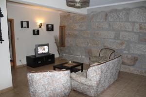 ArcozeloCasa do Adro的客厅配有两把椅子和电视