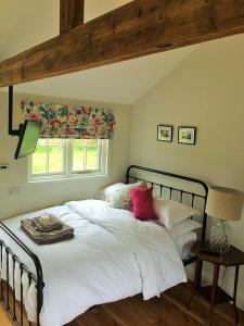 Gilling EastThe Parcel Shed的一间卧室配有带白色床单和红色枕头的床。