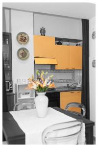 萨莱诺Insidesalernohome的厨房配有黄色橱柜和鲜花桌