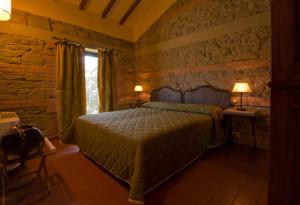 菲伦佐拉格利欧萨里酒店的一间卧室设有一张床和石墙