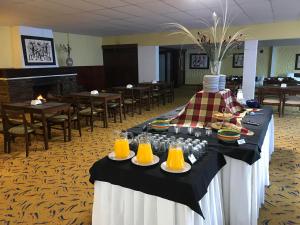 拉帕洛马Hotel Cabo Santa Maria的餐桌,带食物和橙汁盘
