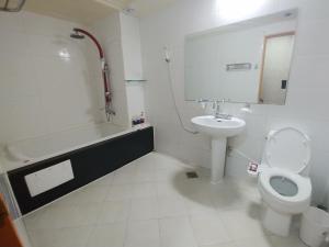 大邱New Grand Hotel的浴室配有卫生间、盥洗盆和浴缸。