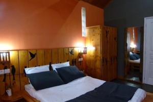 安齐拉贝SOUIMANGA-HOTEL的一间卧室配有一张大床和木制床头板