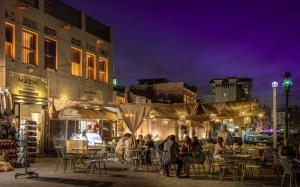 迪拜MAZMI CASA的一群人晚上坐在城市的桌子旁