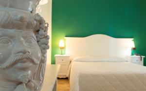 利帕里Hotel Villa Enrica - Aeolian Charme的卧室,床头雕像
