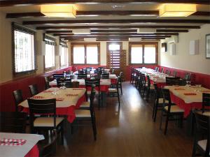 贝塞特Fonda Urquizu的一间带桌椅和红色桌布的用餐室