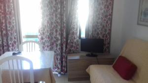内尔哈地中海公寓的客厅配有电视和桌椅