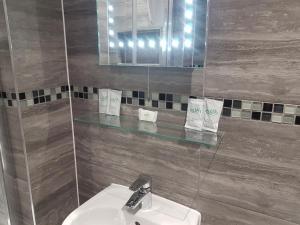 利物浦The Glebe Hotel的一间带水槽和镜子的浴室