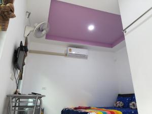 Sanomเซราะกราว โฮมสเตย์的一间拥有紫色天花板和床的客房