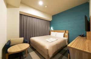 大阪大阪心斋桥相铁弗雷萨酒店的配有一张床和一把椅子的酒店客房