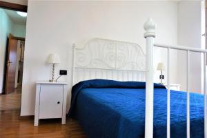 加尔达湖滨Apartment La Coccinella的一间卧室配有一张白色床和蓝色床罩