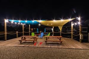 马特里查Matlacha Tiny Village的甲板上设有两张野餐桌和夜间灯光